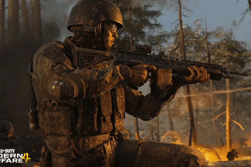 A camouflaged soldier aims a rifle in a burning woodland campaign scene.
